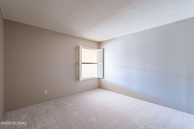 carpeted spare room featuring a textured ceiling