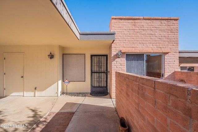 view of exterior entry with a patio