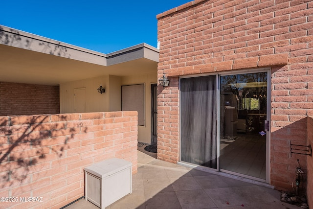 doorway to property featuring brick siding