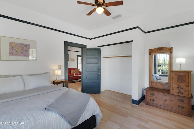 bedroom with visible vents, light wood-style flooring, a closet, baseboards, and ceiling fan