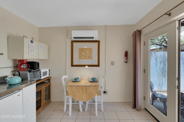 kitchen featuring white microwave, light tile patterned floors, white cabinetry, and a wall unit AC