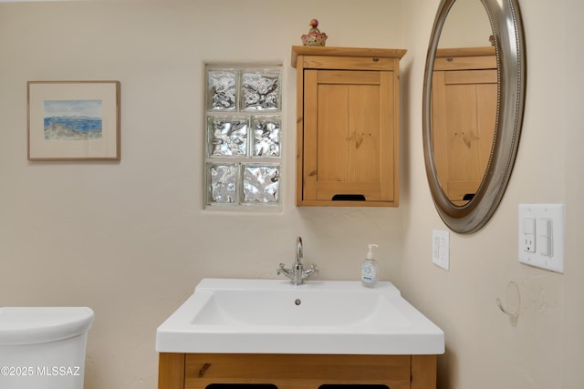 half bathroom featuring vanity and toilet