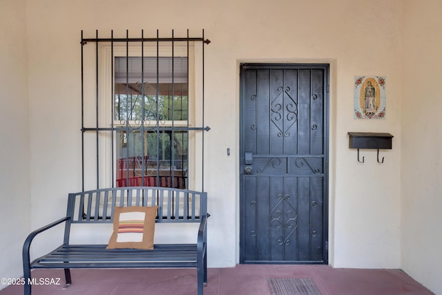 doorway to property featuring stucco siding