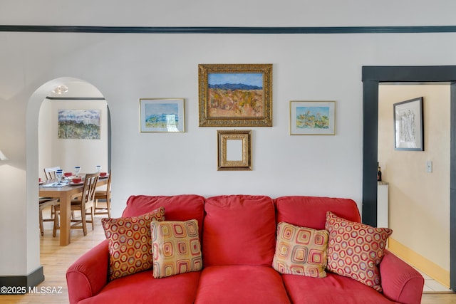 living area featuring arched walkways and wood finished floors