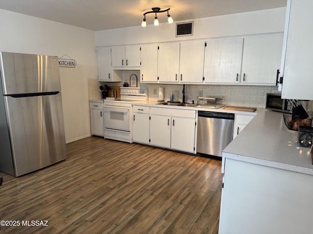 kitchen featuring visible vents, dark wood-type flooring, a sink, tasteful backsplash, and appliances with stainless steel finishes