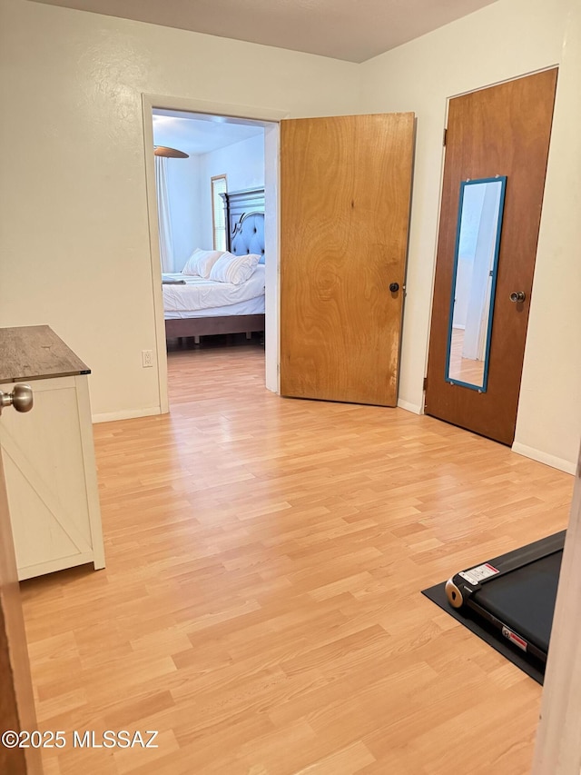 hallway featuring baseboards and light wood finished floors