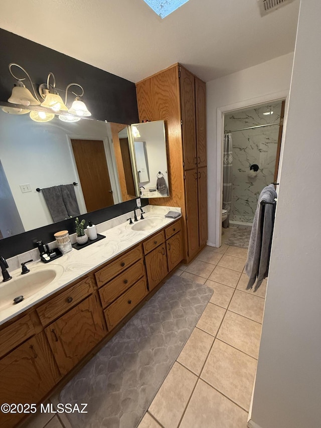 bathroom with tile patterned flooring, walk in shower, toilet, and a sink