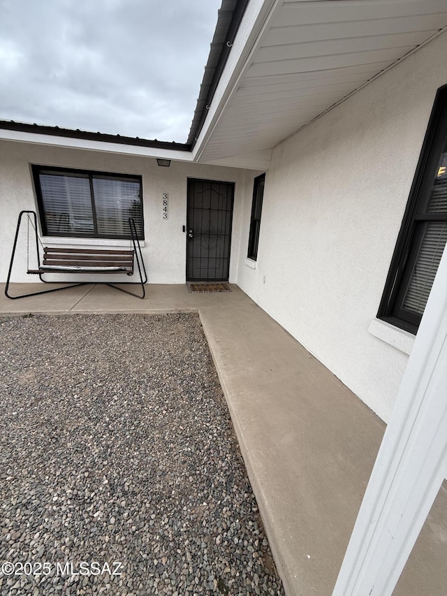 view of exterior entry featuring stucco siding