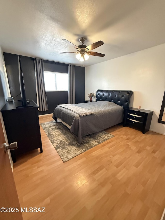 bedroom featuring light wood-type flooring and a ceiling fan