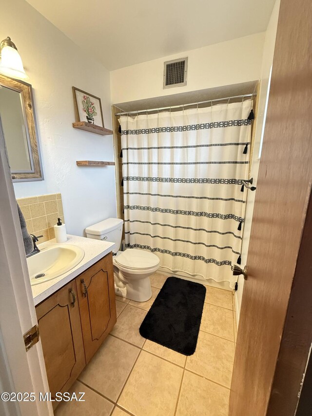 bathroom featuring tile patterned flooring, visible vents, toilet, decorative backsplash, and vanity