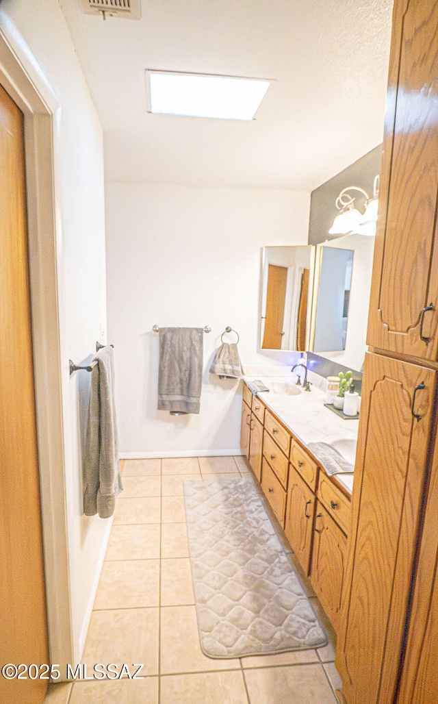 bathroom with a sink, visible vents, double vanity, and tile patterned flooring