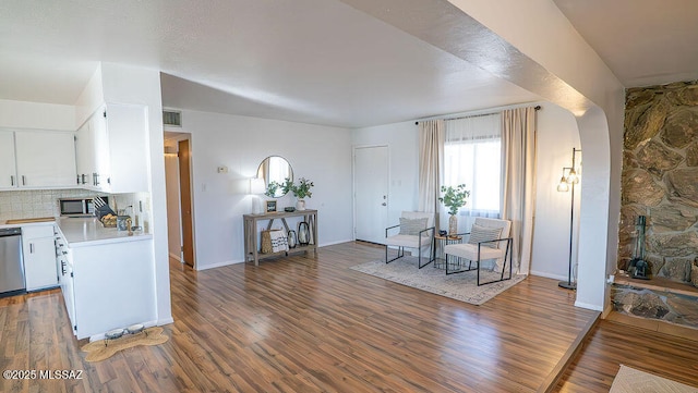 dining space featuring arched walkways, visible vents, and wood finished floors
