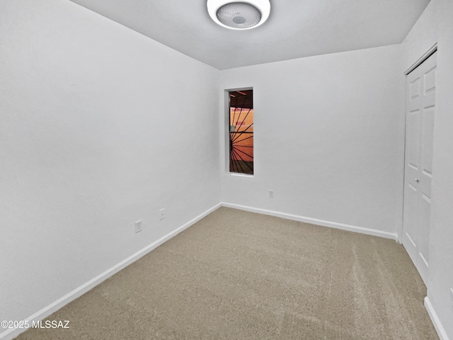 carpeted empty room with baseboards