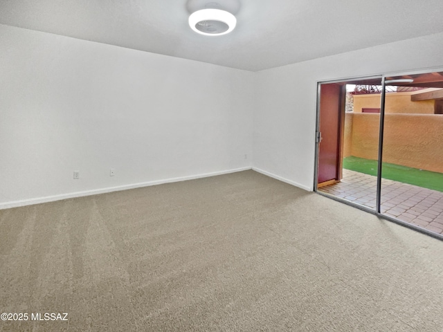 carpeted empty room featuring baseboards