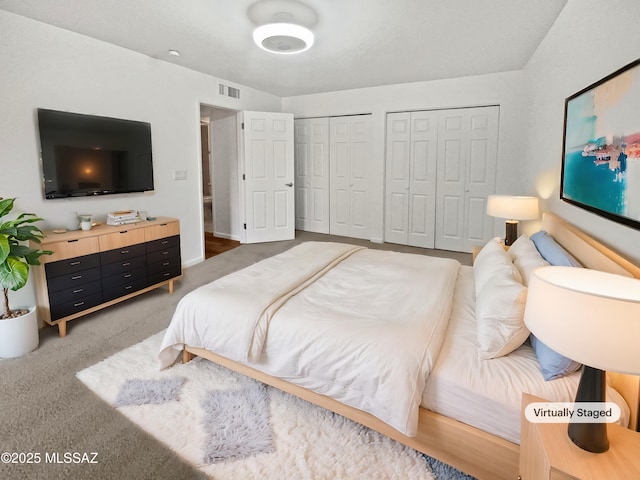 bedroom featuring visible vents and multiple closets