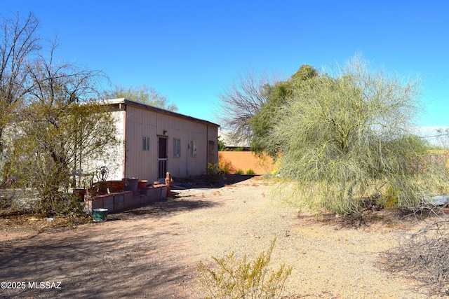 view of property exterior featuring an outbuilding and fence