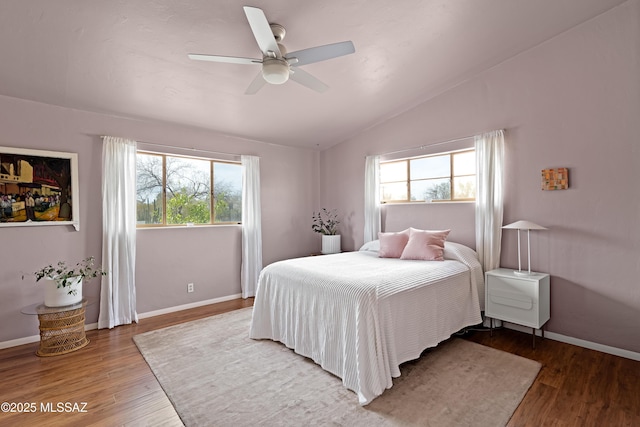 bedroom featuring wood finished floors, ceiling fan, baseboards, and vaulted ceiling