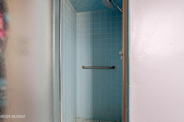 full bath featuring a textured wall and a stall shower
