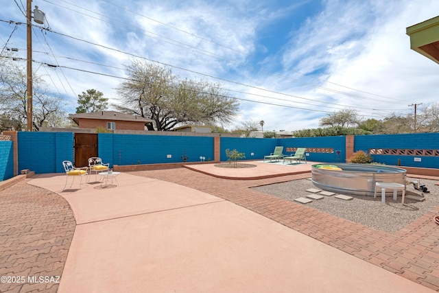 view of patio / terrace with an outdoor fire pit, fence, and a gate