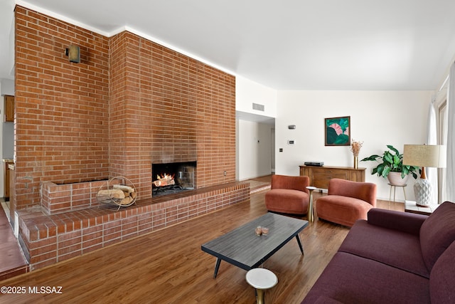 living room with visible vents, wood finished floors, and a fireplace