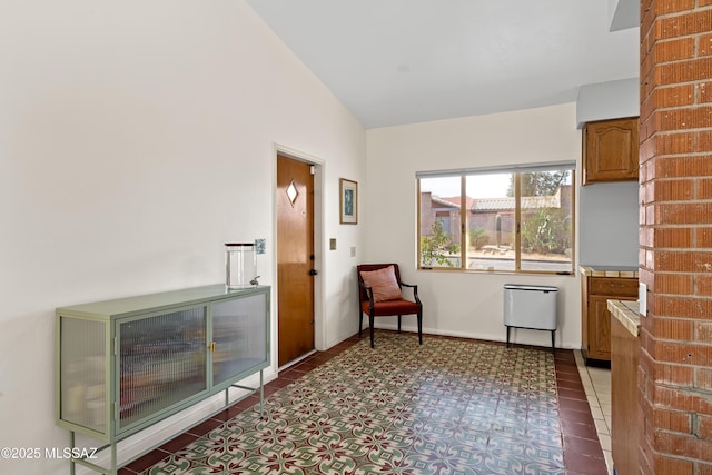 unfurnished room featuring tile patterned flooring, baseboards, and lofted ceiling