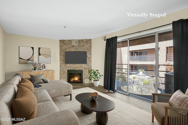 living room featuring visible vents and a stone fireplace