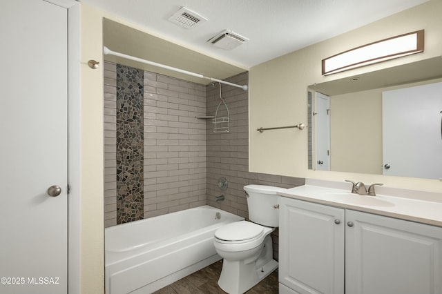 bathroom featuring vanity, wood finished floors, visible vents, shower / bathing tub combination, and toilet