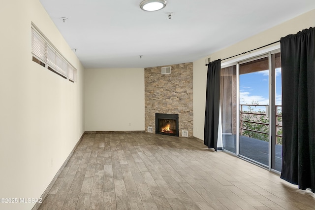 unfurnished living room with visible vents, wood finished floors, and a fireplace