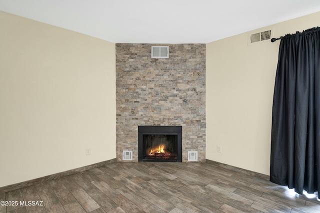 unfurnished living room featuring visible vents and wood tiled floor