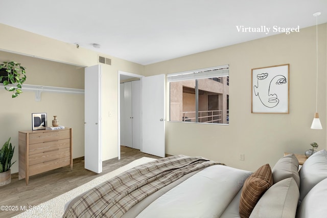 bedroom featuring wood finished floors and visible vents