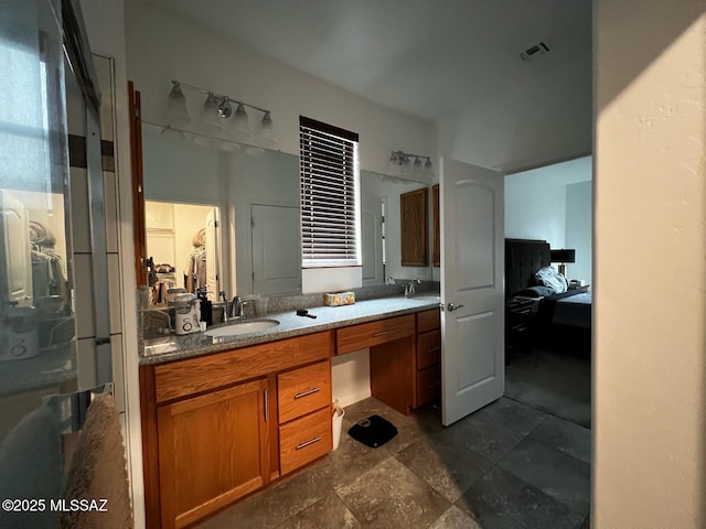 ensuite bathroom featuring double vanity, visible vents, ensuite bathroom, and a sink