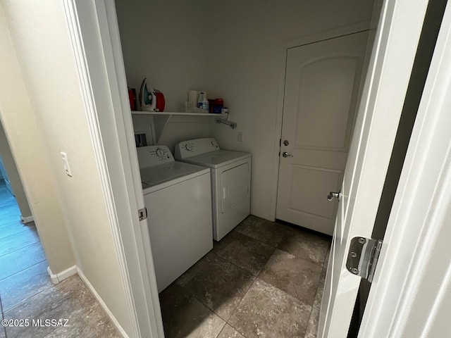 washroom featuring laundry area, stone finish floor, and washing machine and clothes dryer