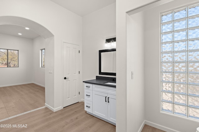 bathroom featuring vanity, wood finished floors, and baseboards