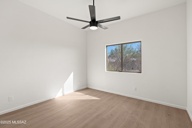 empty room featuring ceiling fan, baseboards, and wood finished floors