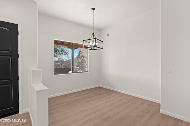 unfurnished dining area with visible vents, a notable chandelier, baseboards, and light wood-type flooring