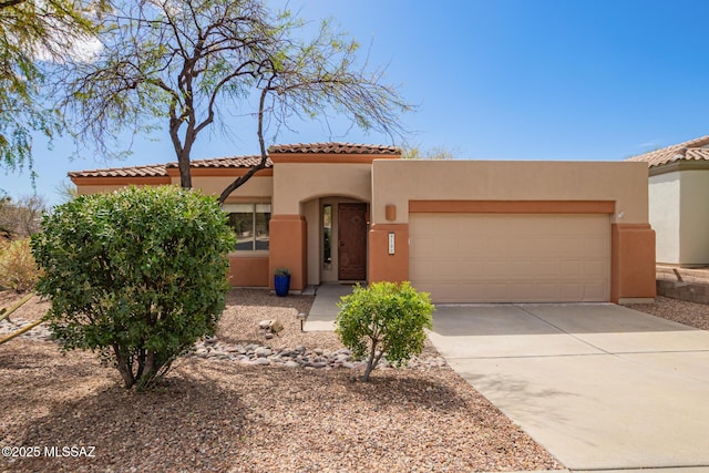 view of front of house with a garage, a tile roof, concrete driveway, and stucco siding