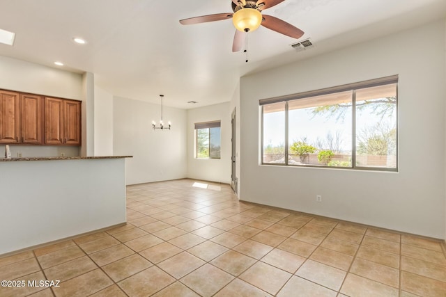 unfurnished living room featuring recessed lighting, light tile patterned floors, ceiling fan with notable chandelier, and visible vents