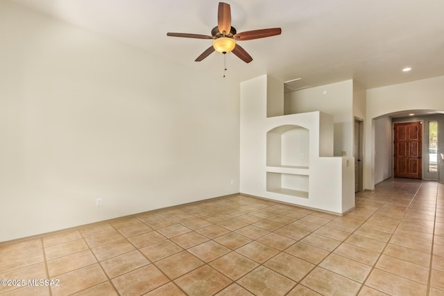 unfurnished room featuring built in features, light tile patterned floors, recessed lighting, arched walkways, and ceiling fan