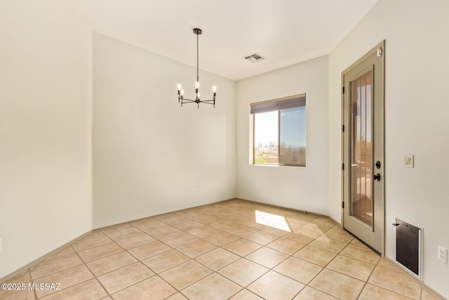 unfurnished room with a notable chandelier, visible vents, and light tile patterned floors