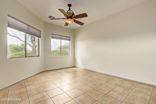 unfurnished room featuring light tile patterned flooring, a ceiling fan, and visible vents