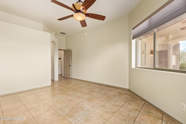 spare room featuring light tile patterned flooring, visible vents, and a ceiling fan