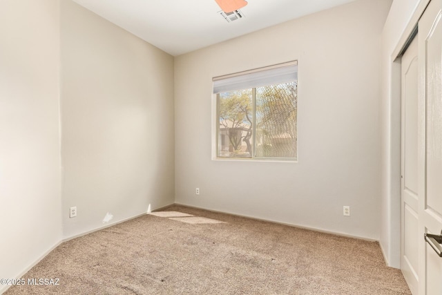 unfurnished bedroom with a closet, carpet flooring, and visible vents