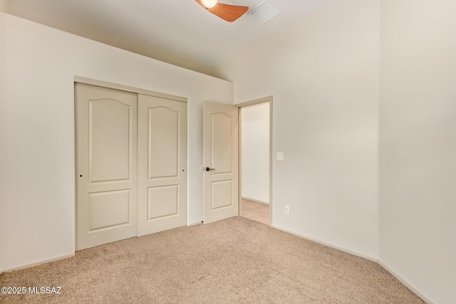 unfurnished bedroom with a closet, carpet floors, and visible vents