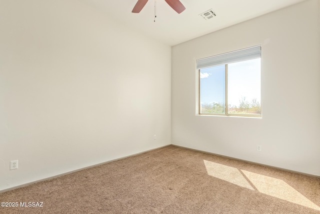 carpeted empty room featuring visible vents and a ceiling fan