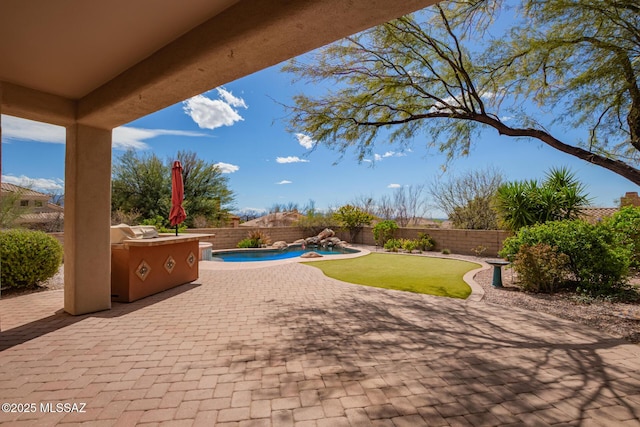 view of patio featuring a fenced backyard, a fenced in pool, and an outdoor kitchen