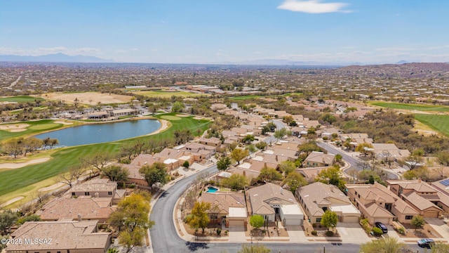 aerial view with golf course view, a water view, and a residential view