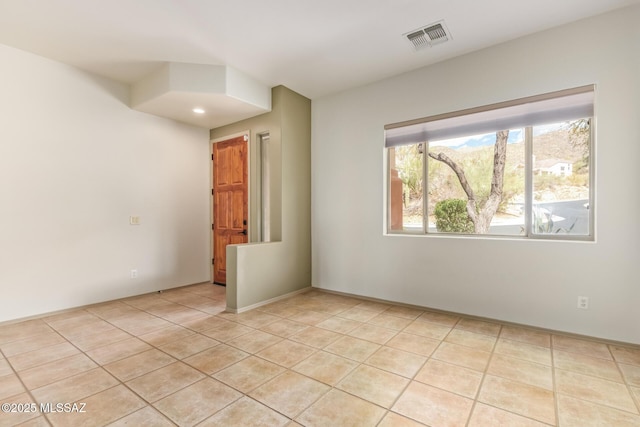 empty room with light tile patterned floors and visible vents