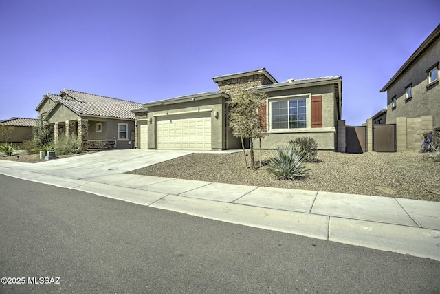 view of front facade with concrete driveway, a garage, and stucco siding