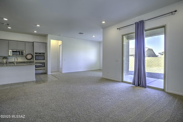 unfurnished living room with recessed lighting, visible vents, and light carpet