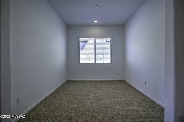 spare room with baseboards and carpet floors